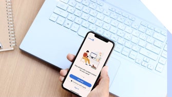 A hand holding a phone with the LinkedIn login page on screen