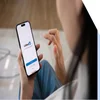 Woman holding a mobile phone with the LinkedIn login page on screen