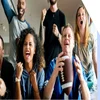 A group of football fans watching the TV and celebrating