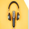 yellow surface with microphone and headphones placed in the center
