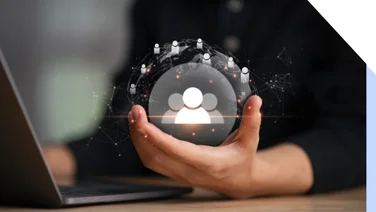 Hand holding visual art of the world, with people icons scattered over its surface and three large people icons in the middle of the sphere