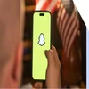 hand holding phone with snapchat logo on