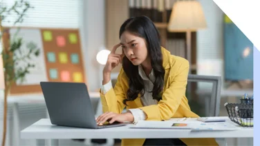 Woman looking puzzled and frustrated as she looks at a laptop