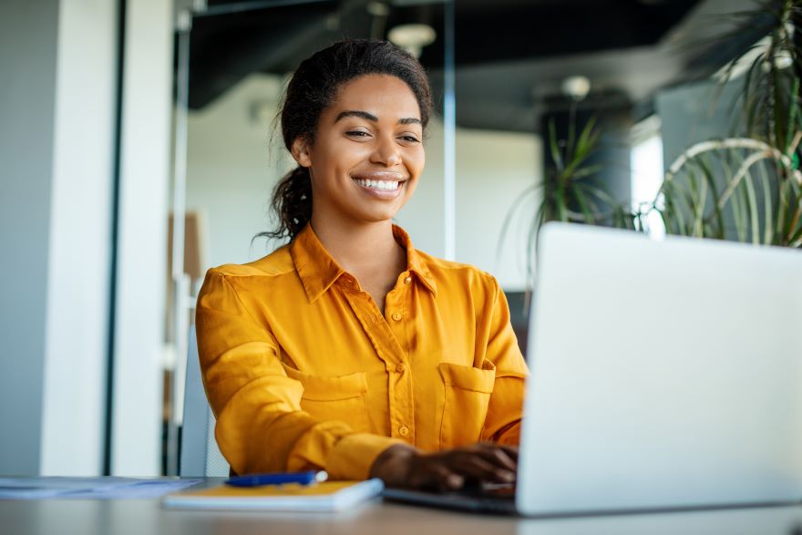 Top LinkedIn Feature In Article Photo A woman smiling at her laptop