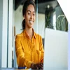 A woman smiling at her laptop