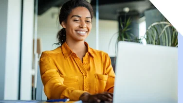 A woman smiling at her laptop
