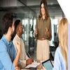 A woman manager happily talking to work team that is sat around a desk