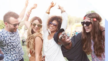 A group of 5 friends dancing together at a festival