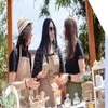 Three women merchants standing by their candle stall and chatting