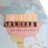A closeup of the US on a map with letter blocks spelling "tariffs" on top