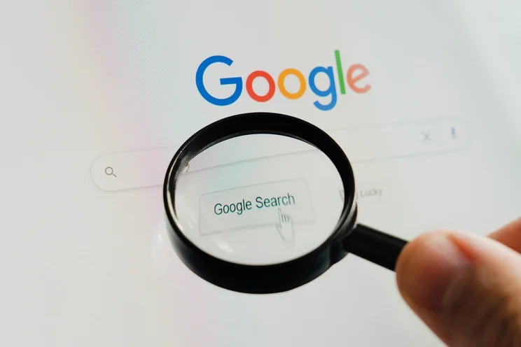 Magnifying glass hovering over the Google homepage search bar