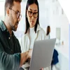 A man and woman starting at a laptop together