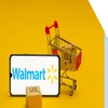 walmart logo on horizontal phone propped up by a small shopping cart with boxes in it