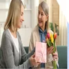 Daughter sharing gifts and flowers with her mother for Mother's Day