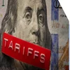 US money with a printed label on top saying tariffs