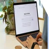 Hands typing on a laptop with the Google AI Mode landing page on screen