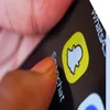 Close up image of a thumb tapping the snapchat logo on a smartphone homepage