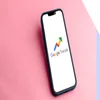 smartphone with the Google Trends logo on screen laying on a pink surface