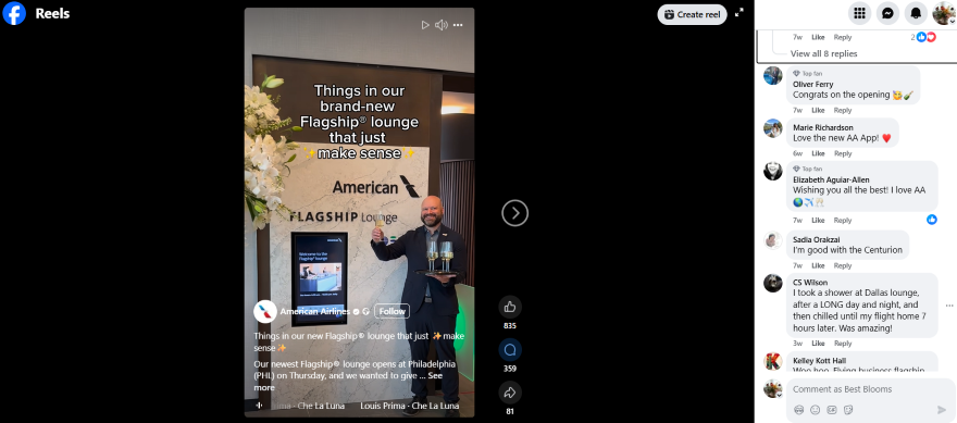 A staff member presents a drink in front of the American Airlines Flagship Lounge signage, adorned with flowers.