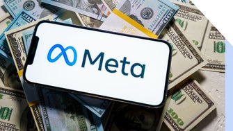 smartphone with meta logo on screen laying on top of a pile of cash