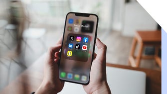 A person holds a smartphone displaying a folder labeled 
