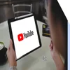 person holding ipad with YouTube logo full screen