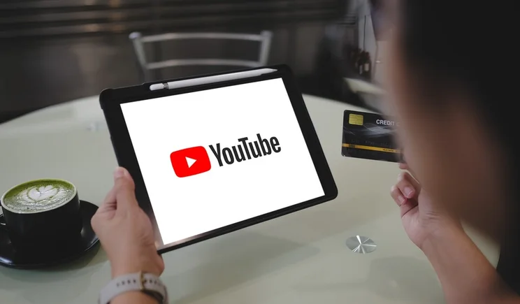 person holding ipad with YouTube logo full screen