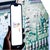 A hand holds a smartphone displaying the Google Reviews logo against a blurred circuit board background.