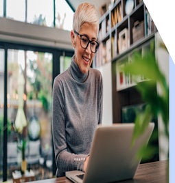 Woman with glasses working at a laptop in her home
