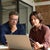Man and woman working together at a laptop in an office space