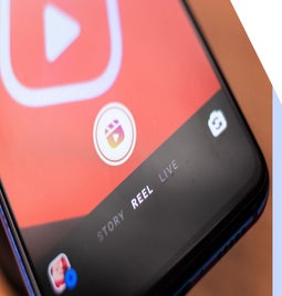 Close-up of a smartphone screen displaying a video app interface with options for 'Story,' 'Reel,' and 'Live' highlighted.