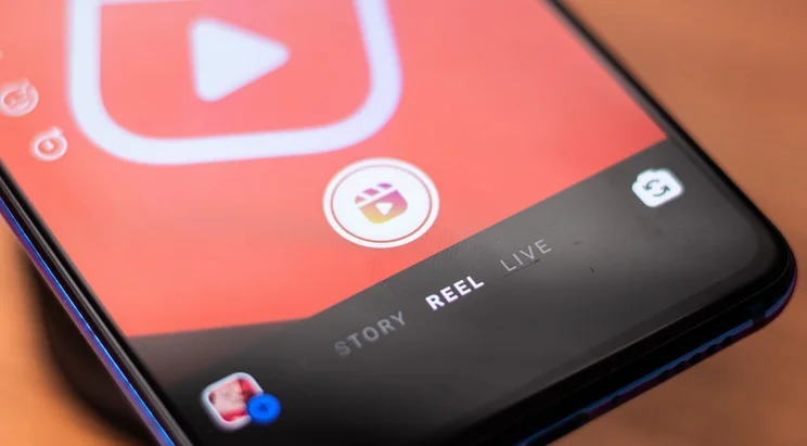 Close-up of a smartphone screen displaying a video app interface with options for 'Story,' 'Reel,' and 'Live' highlighted.