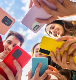 Circle of friends holding their phones together