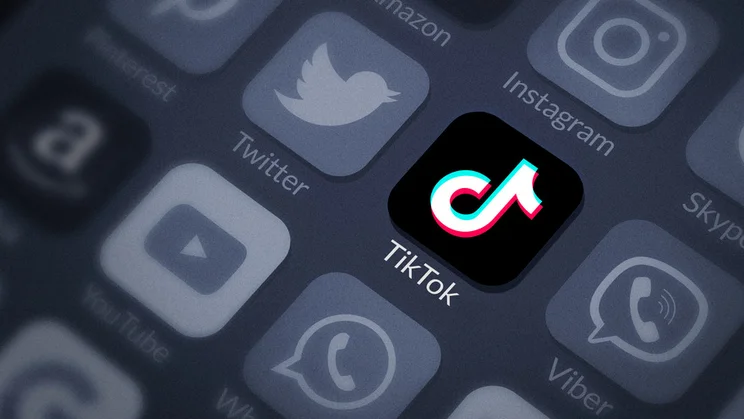 TikTok app logo highlighted with greyed out social media icons around it