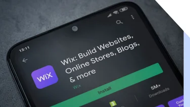 Wix app on a smartphone screen showcasing its features for building websites, online stores, and blogs, with an Install button.