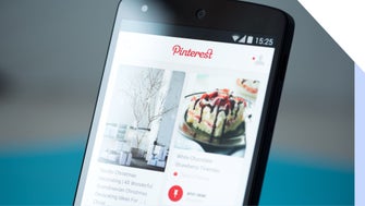 A smartphone displaying the Pinterest app, featuring holiday decor ideas and a dessert recipe, showcased on a colorful interface.