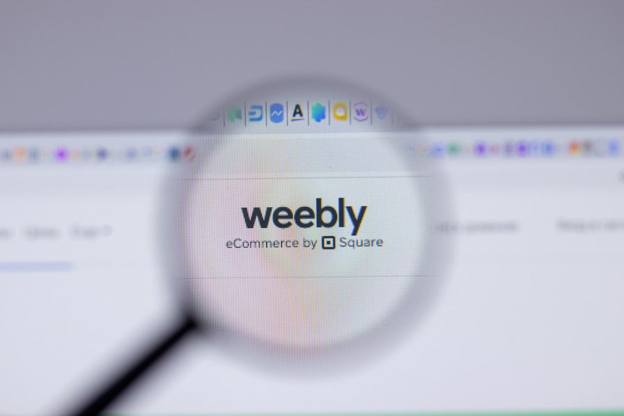 Weebly logo on a desktop visible under a magnifying glass