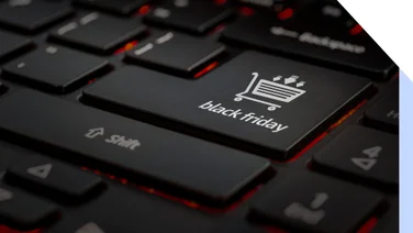 Close-up of a black keyboard highlighting a key labeled "black friday" with a shopping cart icon, set against a dimly lit background.