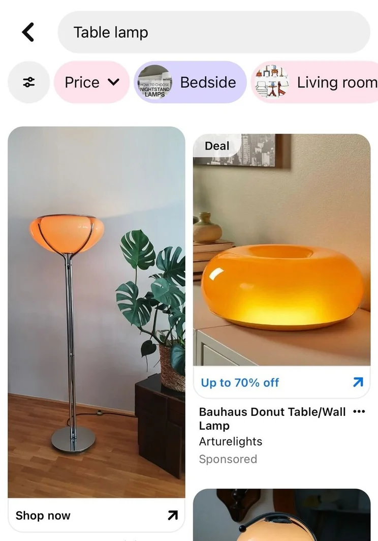 Pinterest search for the term "table lamp" showing ads of a stylish floor lamp with a round, orange shade next to a modern donut-shaped table lamp, both glowing softly.