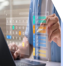 Digital image of a calendar and colour coded checklist floating above a laptop with a hand pointing to the list with a stylus