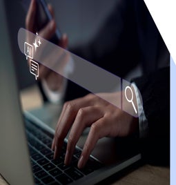 Person typing at a laptop keyboard with a transparent search bar powered by AI hovering above the hands